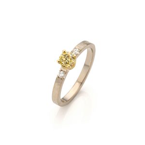 Handgemaakte witgouden ring met hamerslagstructuur, geelgouden zetting met groen gele diamant en twee kleine witte diamanten naast de zetting.